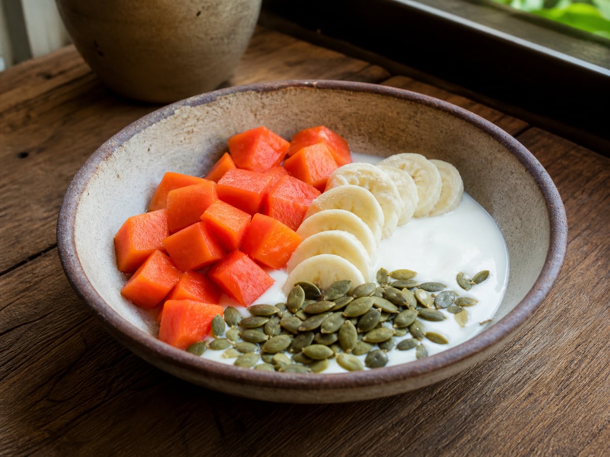 Yogur natural con fruta y semillas servido en una porción casera con ingredientes visibles