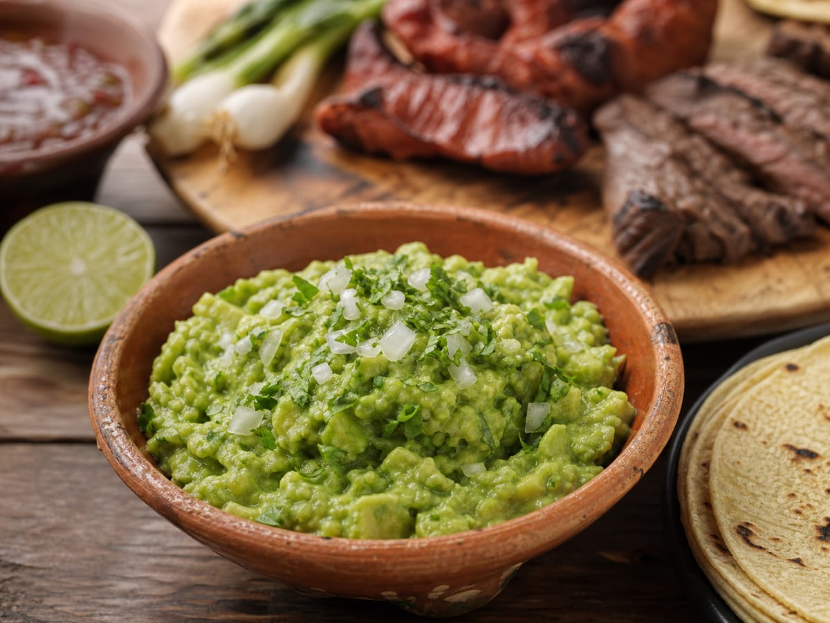 Guacamol chapín rústico con aguacate, cebolla, cilantro y limón en un tazón